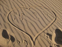 footprints in the sand in the shape of a heart